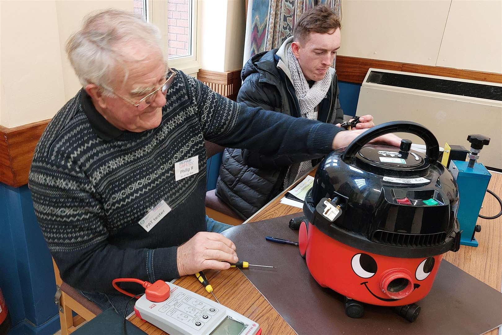PAT test volunteers inspecting a Henry Hoover at the Repair Cafe