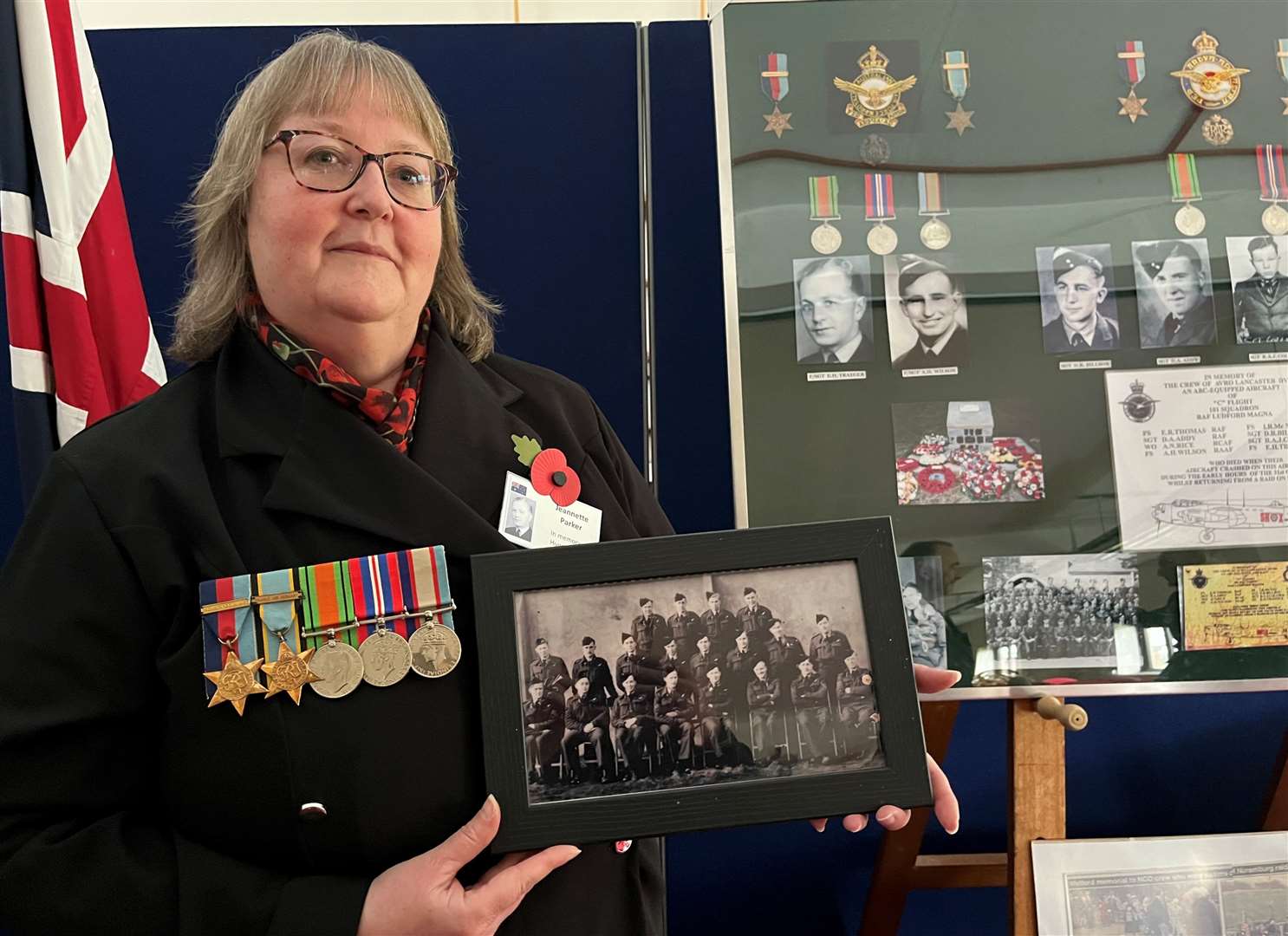 Jeannette Parker holding a squadron photo featuring her great-uncle who was killed in the crash. Credit: Mirek Gosney