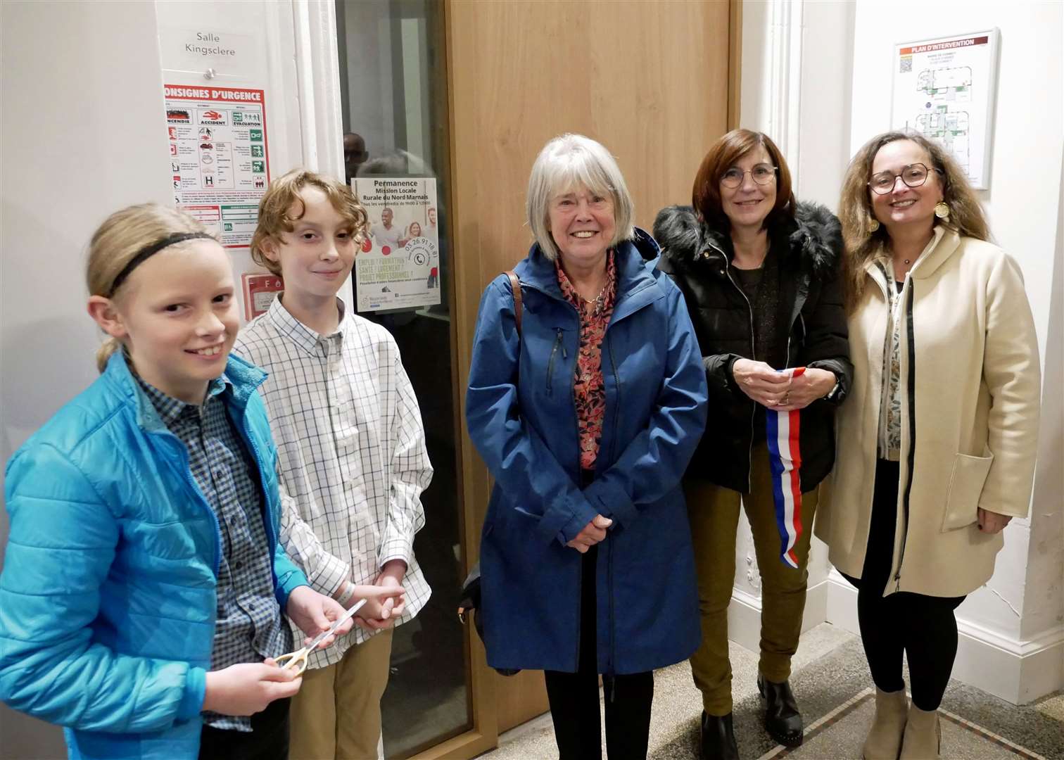 Lucy and William Read, chair of Kingsclere Twinning Association Sue Watson, Cormicy mayor Chantal Lantenois, and chair of Cormicy Twinning Association Claudine Villaume in front of the door of the Kingsclere video conferencing room, after the cutting of the ribbon