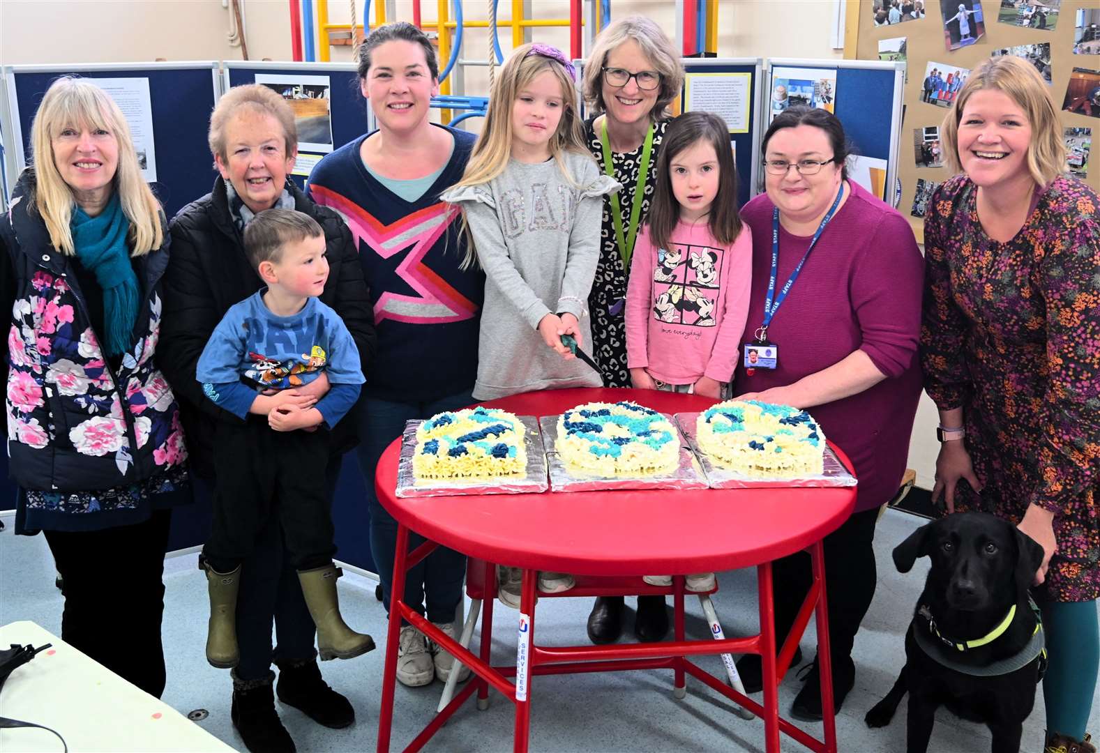 Headteacher, Alison Stevenson, with parents, teachers and pupils Emily, 8, and Sophie, 6, cutting anniversary cake