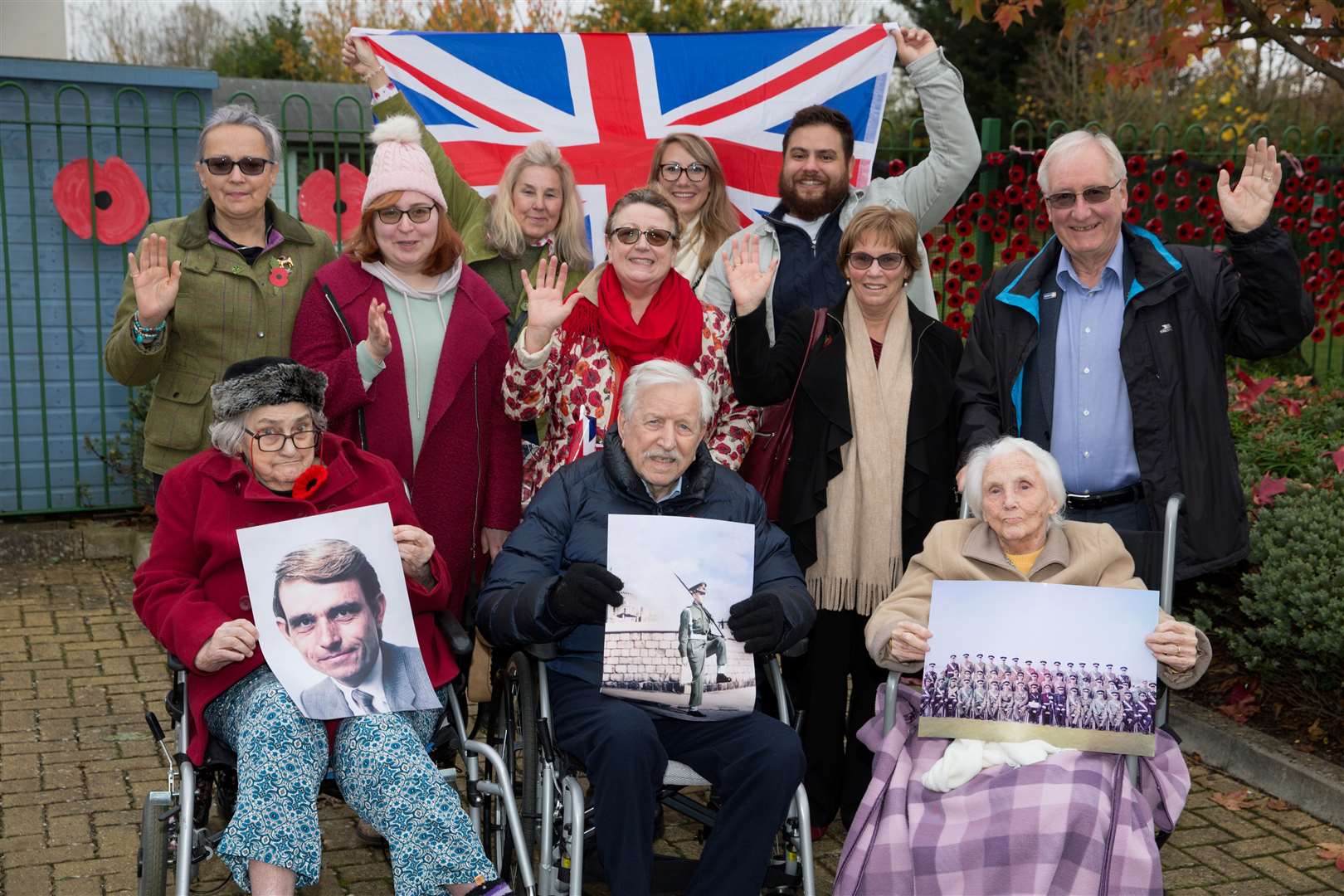 Winchcombe Place residents holding photos of themselves or their loved ones who fought in the war