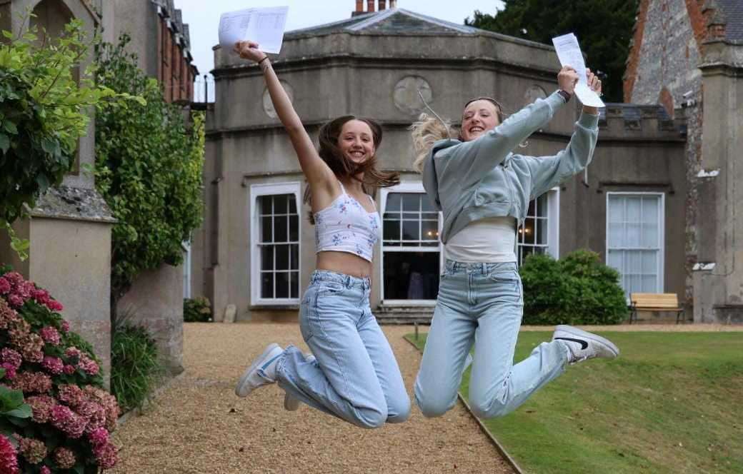 Twins Mia and Neve Wright, both 16, jump for joy as they celebrate their GCSE results at St Gabriel's School in Newbury Picture: Phil Cannings