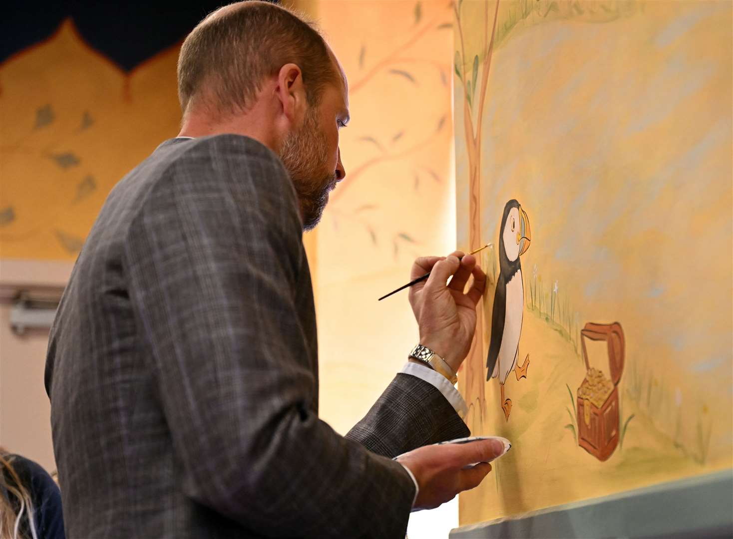 The prince helped paint a mural in the Aros Hall community hub (Oli Scarff/PA)