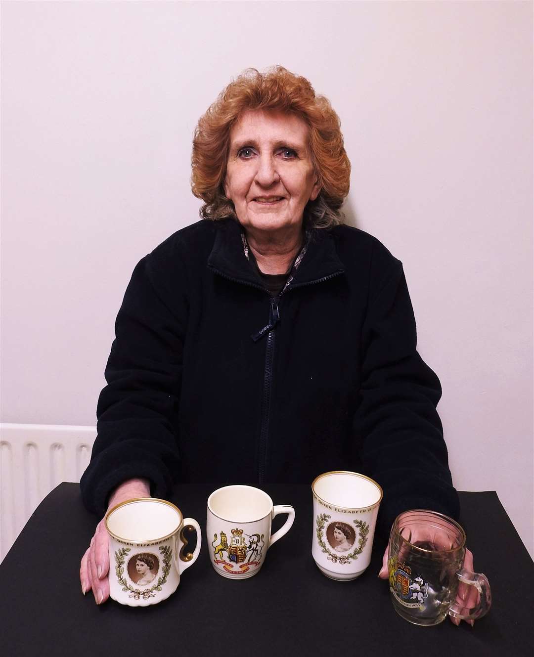 Liz Beard with the souvenir mugs she received at age five