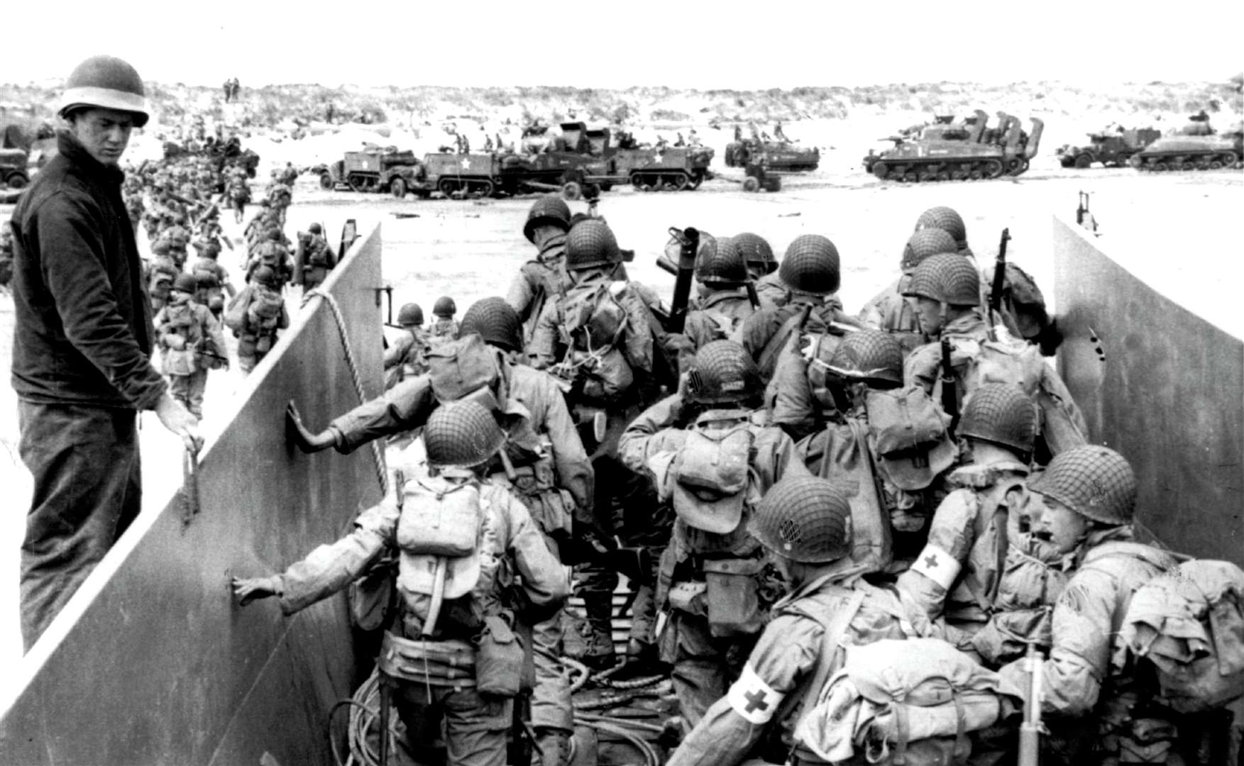US soldiers disembark from a landing craft during the Normandy landings. Sherman tanks like Cecil’s are visible in the background. Credit: PA Photos / DPA, UK Use Only