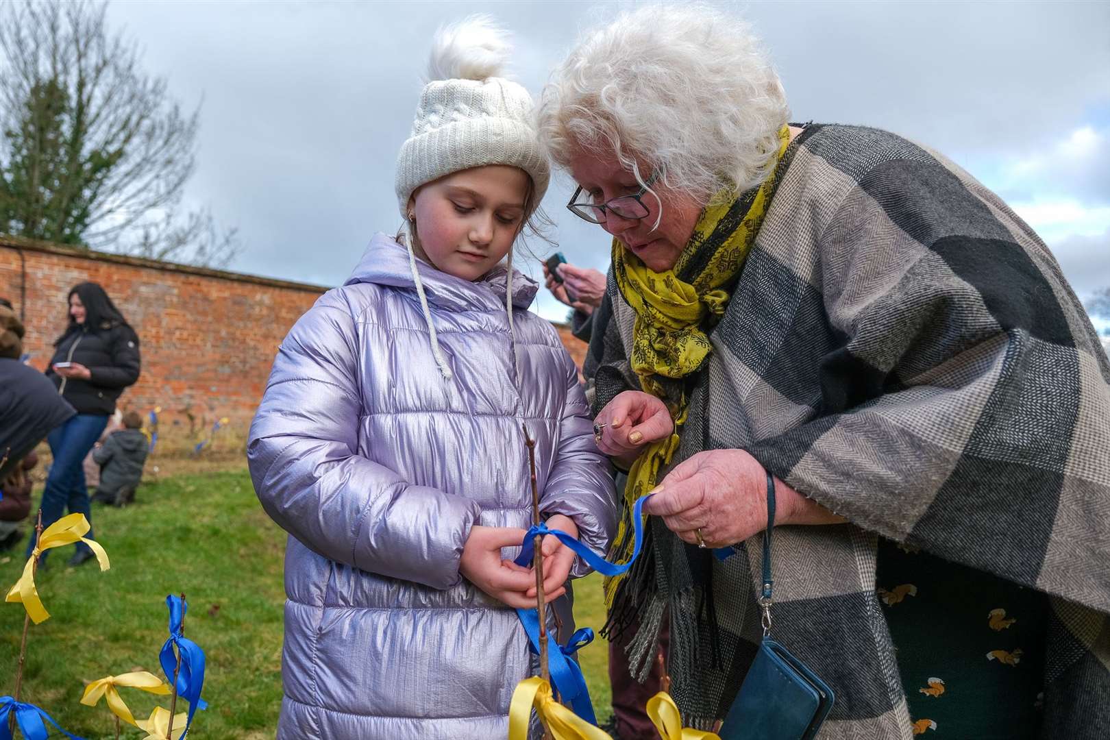Ukraine children putting ribbons onto the trees at Shaw House