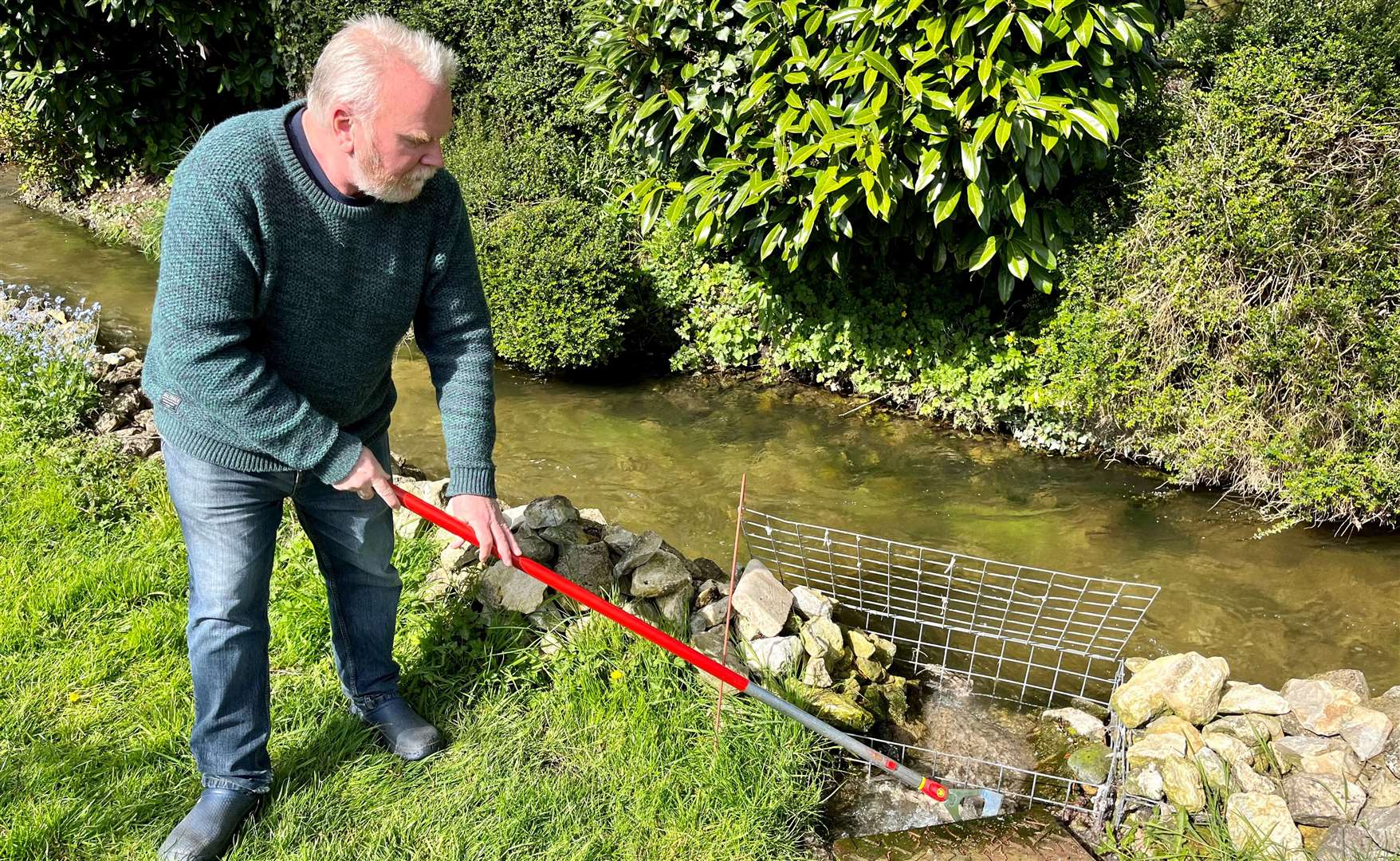 Mr Miller scraping human waste from his clogged-up manhole. Credit: Mirek Gosney