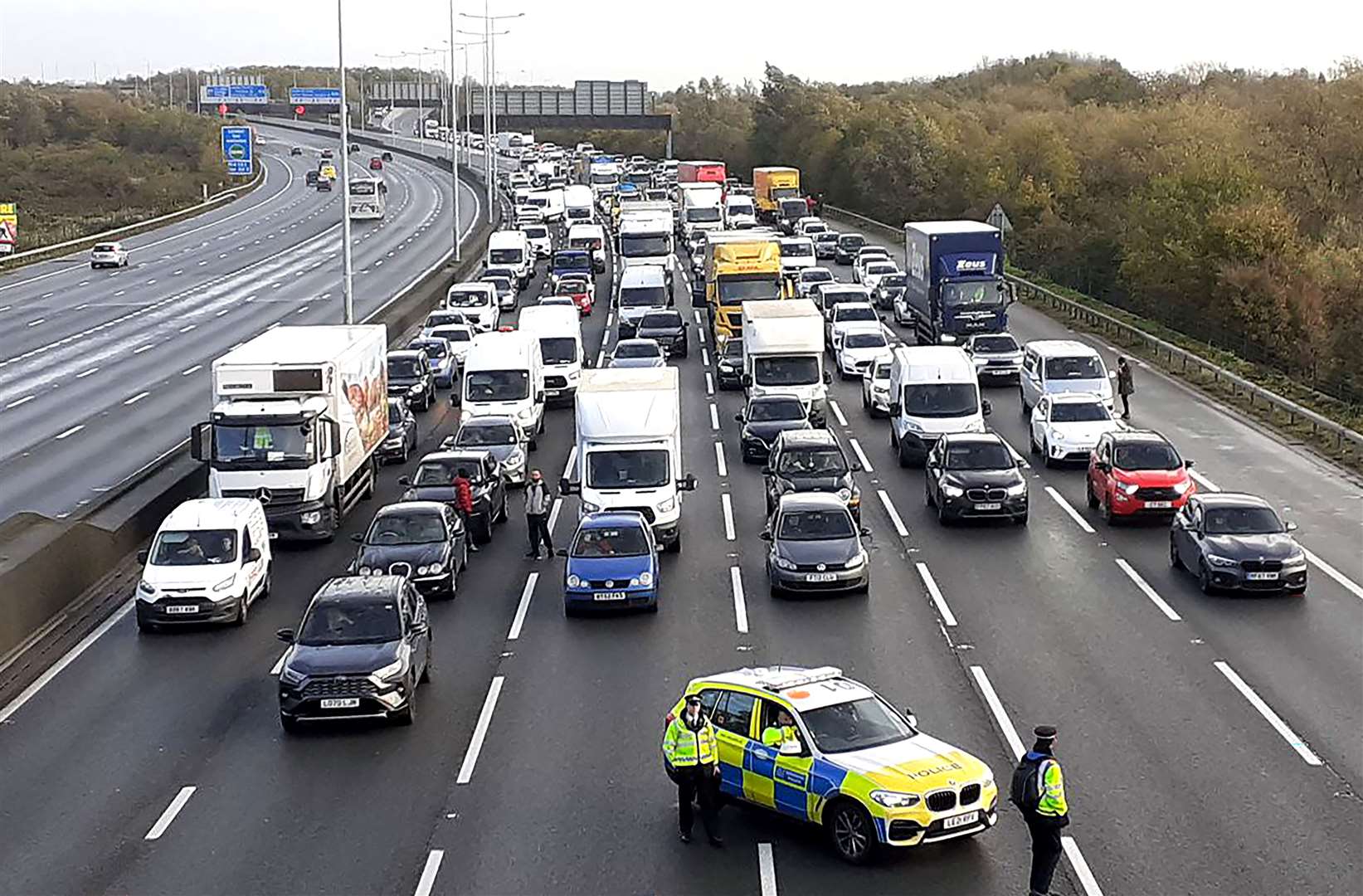 Police closing the M25, where a demonstrator from Just Stop Oil climbed the gantry in 2022 (Just Stop Oil/PA)