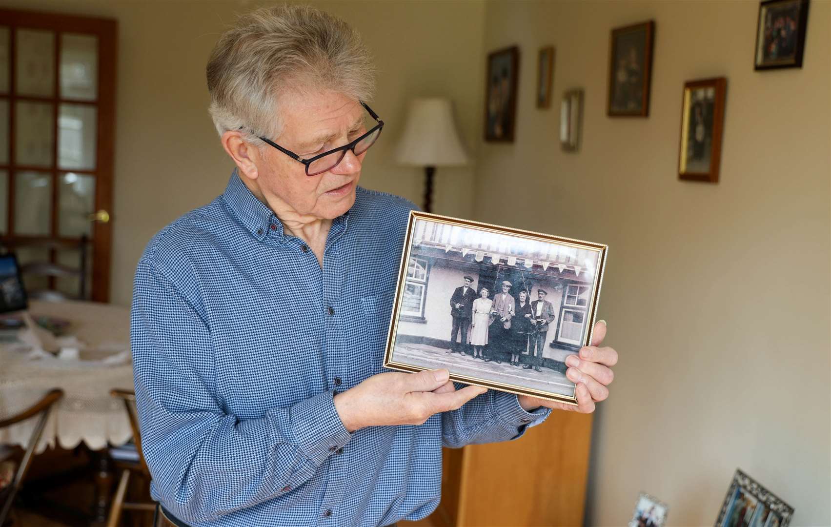Colin Young holding the photo of his grandparents who ran The Halfway Inn
