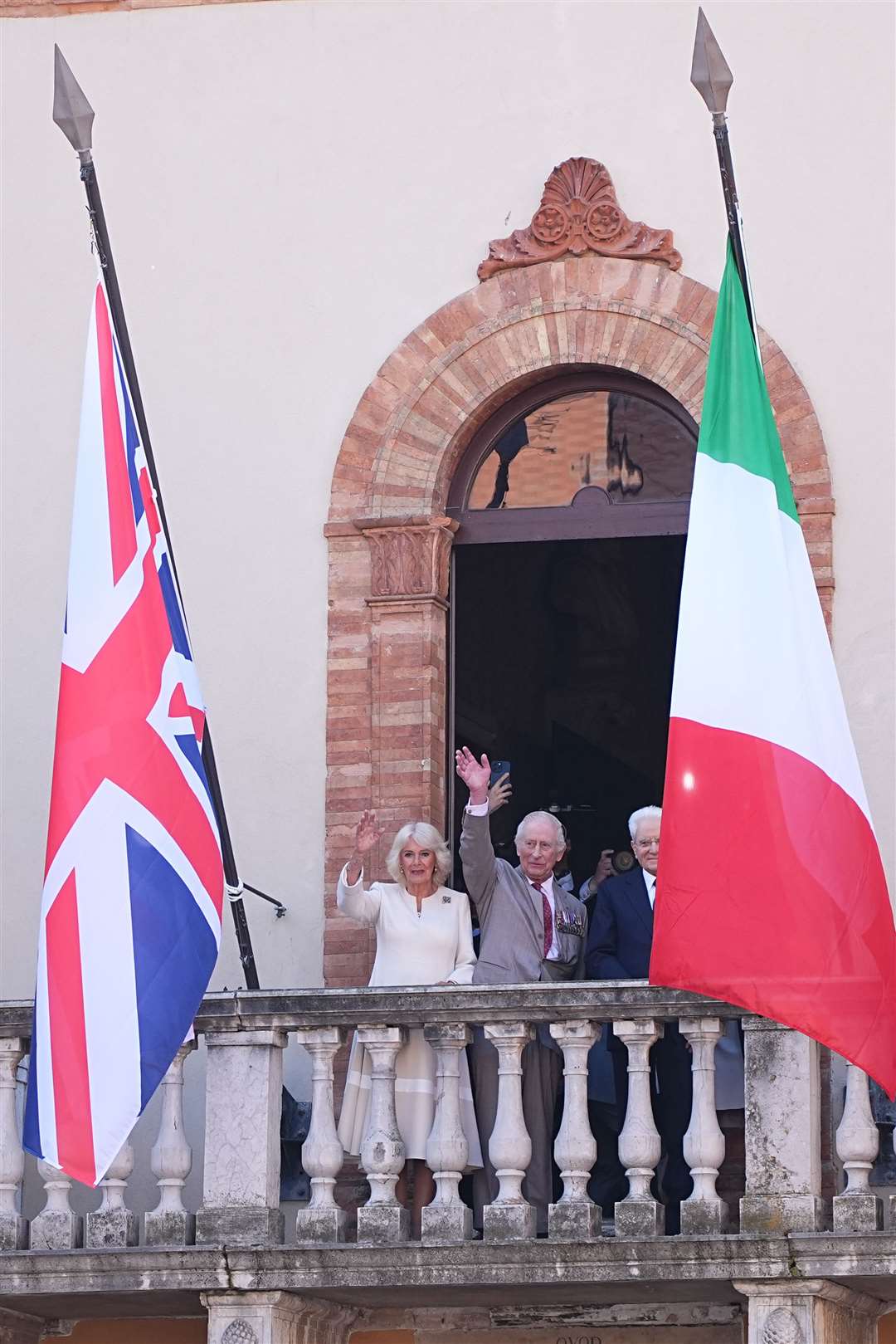 Charles and Camilla wave from a balcony in the Piazza del Popolo (Aaron Chown/PA)