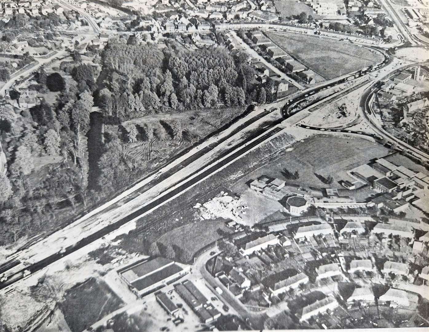 The Robin Hood roundabout being built in 1975. It was part of the construction of the A339, a £2m road built to speed up traffic between Newbury and the M4 at Chieveley. The photograph shows the road from the point where it crosses the River Lambourn (left), cutting over the re-routed A4 to the London Road roundabout. The link is a dual carriageway road though out its three-mile length and includes seven bridges and three subways.