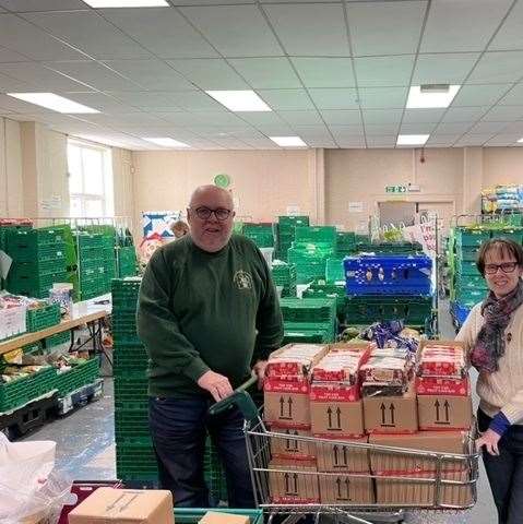 Jim Skinner from Pangbourne Rotary is seen presenting a trolley-load of cakes to Alison Peyton from Readifood