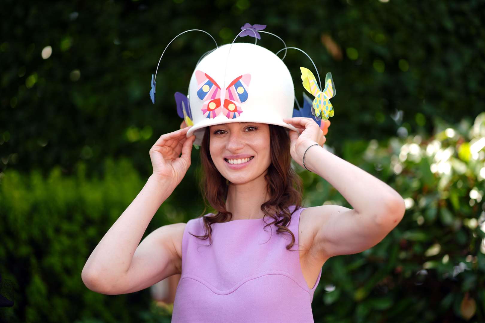 A racegoer modelling an Odette and Elliott hat created for fashion designer Francini Keiser (John Walton/PA)