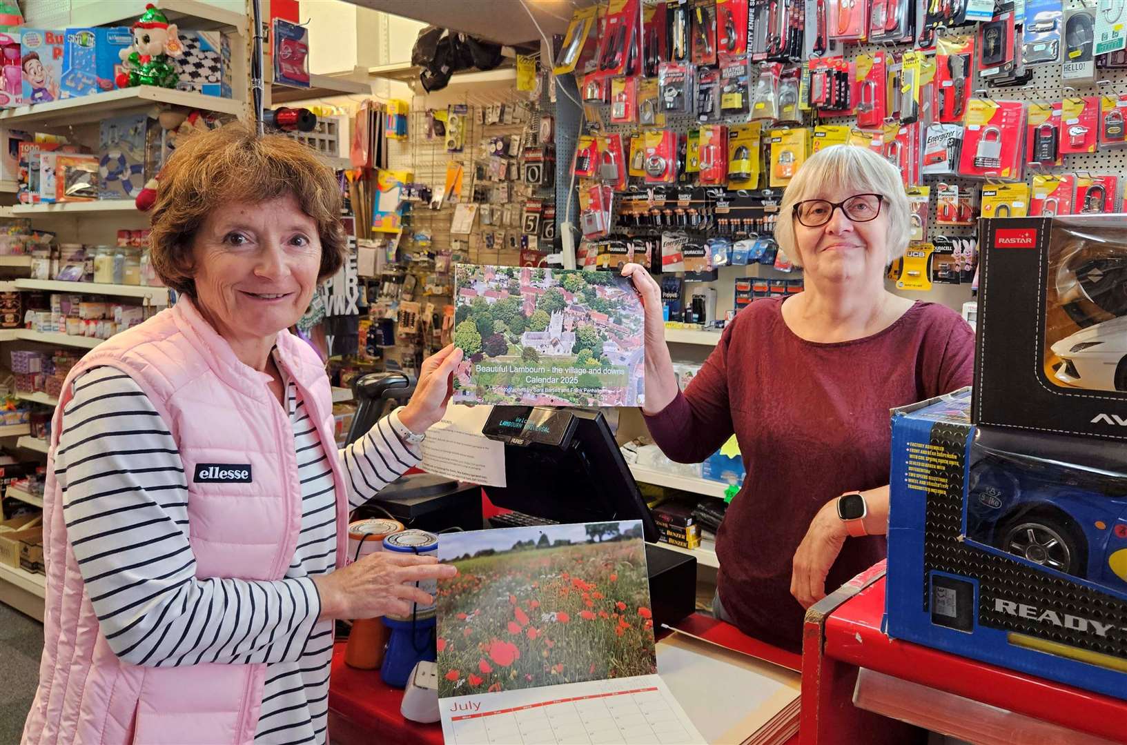 Sara Bartlett, left, hands the calendars to shopkeeper Wendy Read